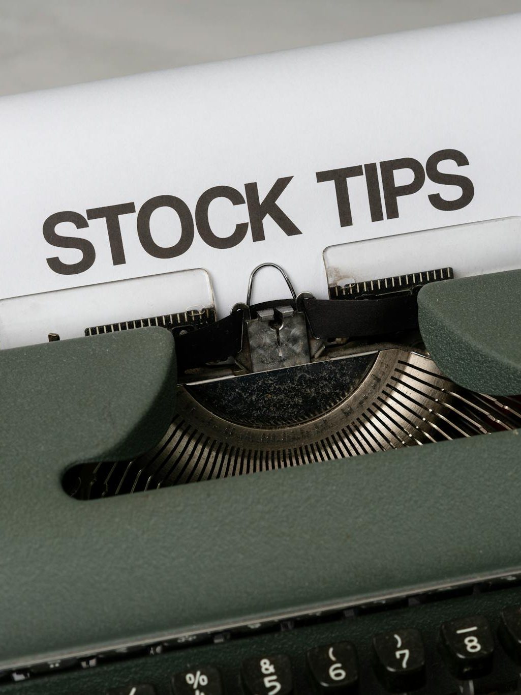 Old-fashioned typewriter displaying stock market tips, symbolizing retro finance advice.